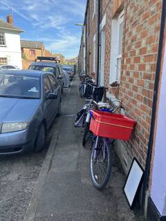 cycles parked on narrow footway, locked up to terraces