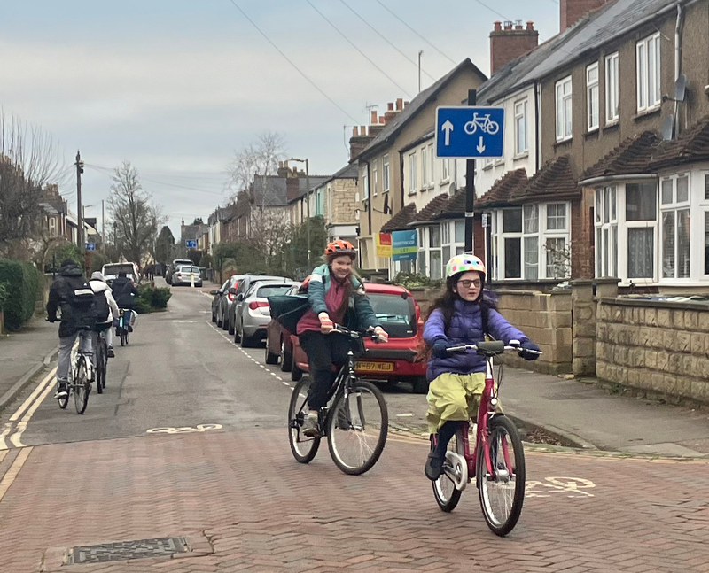 two year six girls cycling towards the photographer, three secondary children cycling away